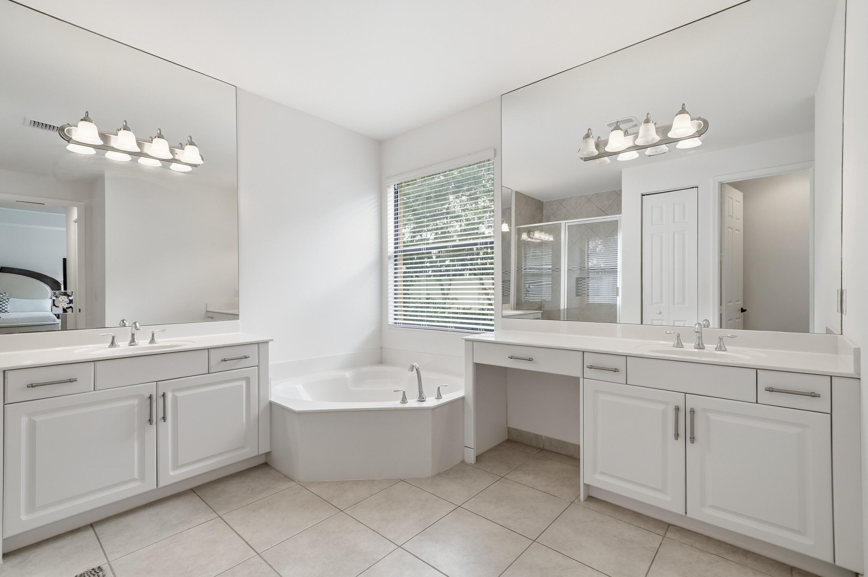 14085 Paverstone Terrace Delray Beach, FL 33446 - Photo 28 of 46 a bathroom with a double vanity sink bathtub and a window