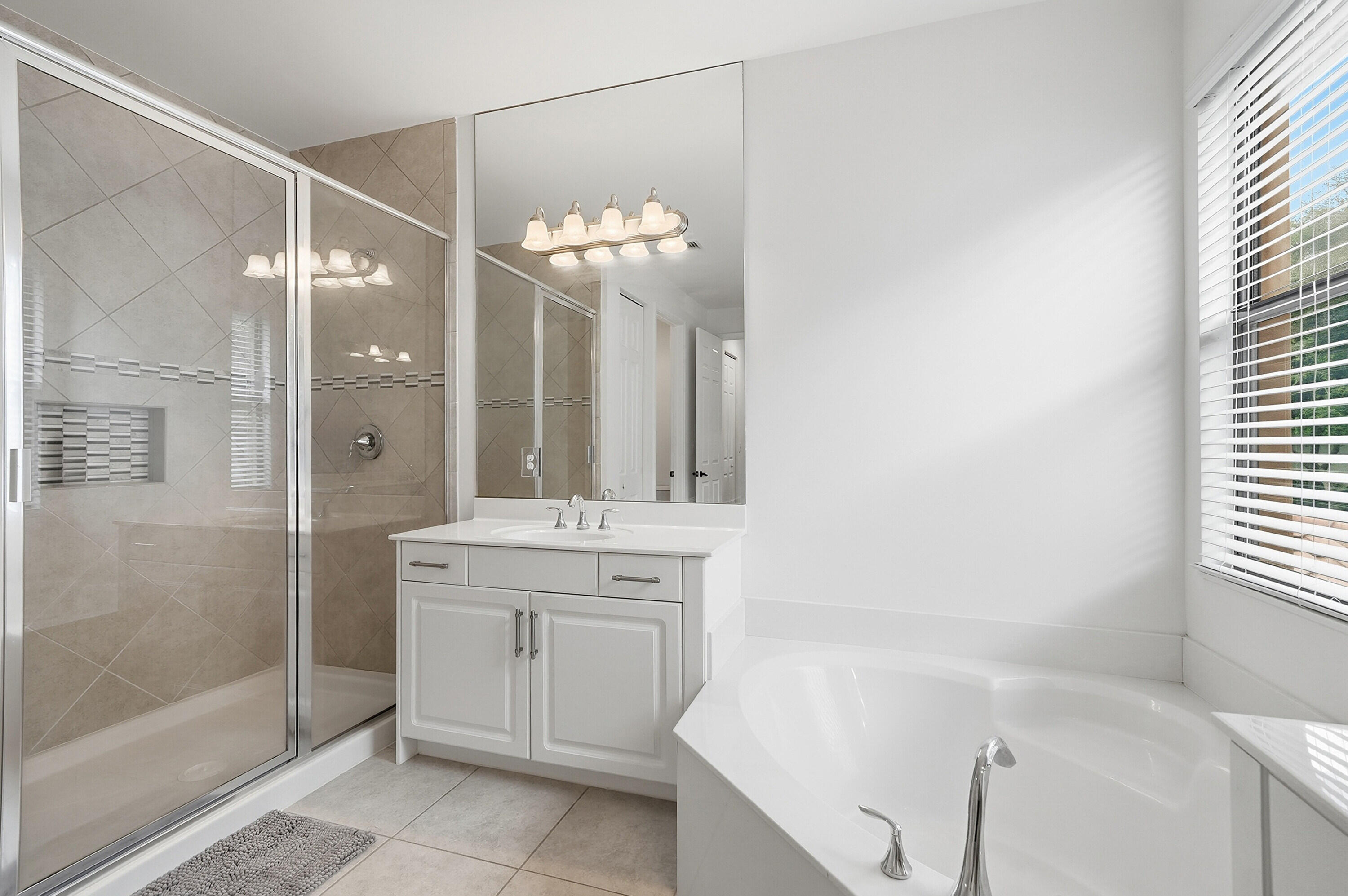 14085 Paverstone Terrace Delray Beach, FL 33446 - Photo 29 of 46 a bathroom with a tub sink and mirror