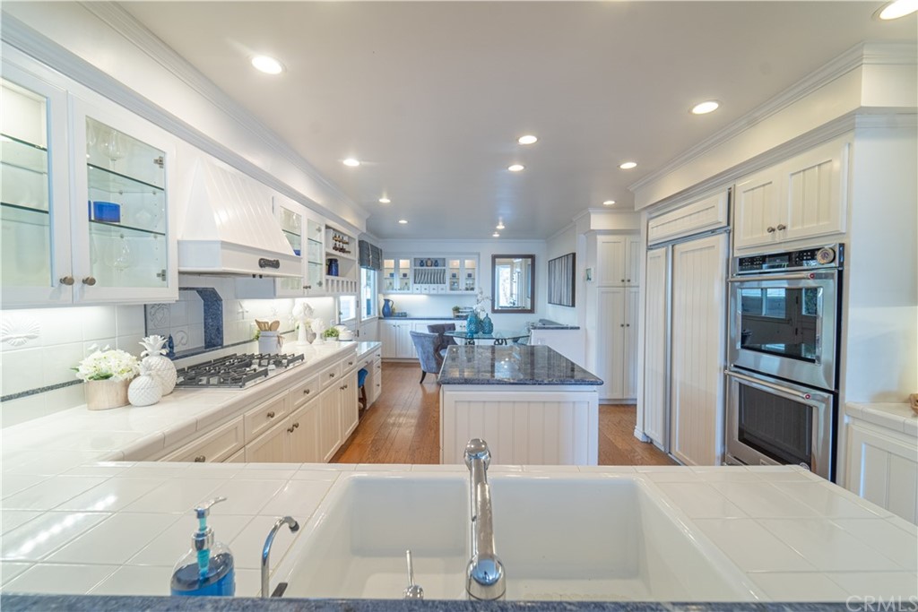 16631 Edgewater Lane Huntington Beach, CA 92649 - Photo 24 of 55 a large kitchen with stainless steel appliances kitchen island granite countertop a refrigerator and a sink