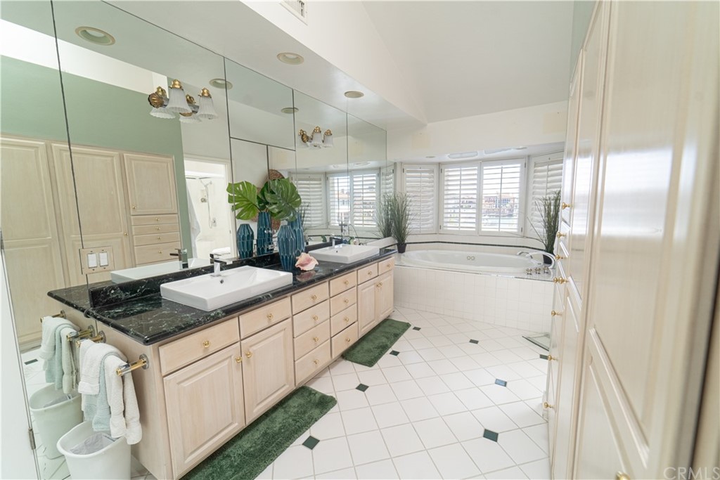16631 Edgewater Lane Huntington Beach, CA 92649 - Photo 37 of 55 a bathroom with a granite countertop sink a toilet a mirror and shower