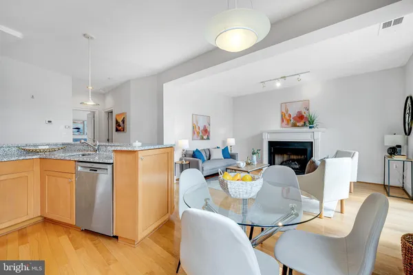 a dining room with furniture a fireplace and a kitchen view