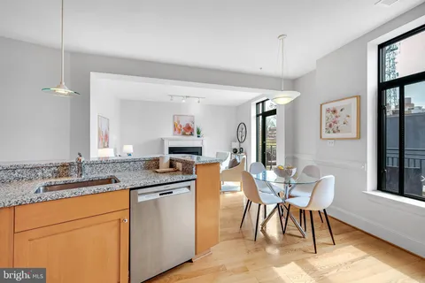a kitchen with granite countertop a sink stove and cabinets