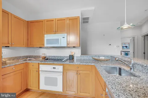 a kitchen with stainless steel appliances granite countertop a sink a refrigerator and a stove