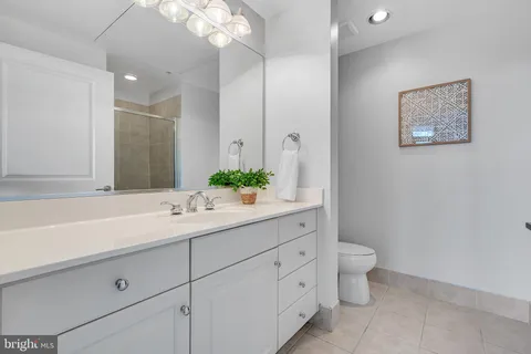 a en suite bathroom with a double vanity sink a mirror and a shower