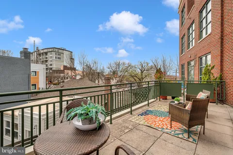 a view of a balcony with chairs and a potted plant