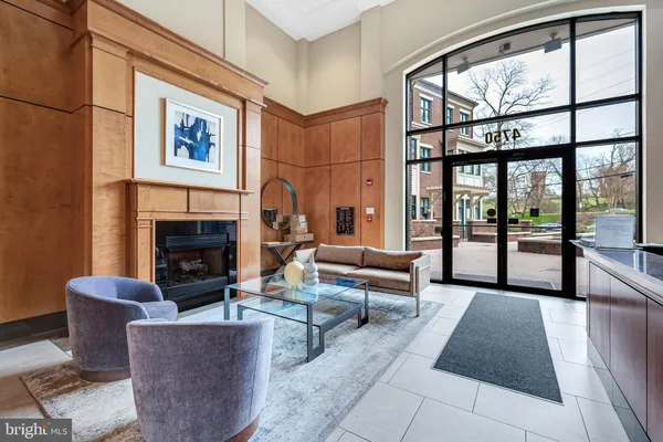 a living room with furniture a large window and a fireplace