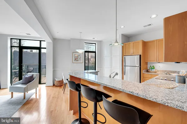a kitchen with stainless steel appliances granite countertop sink refrigerator and cabinets
