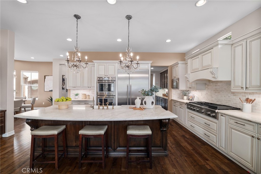 6364 Hidden Brook Place Rancho Cucamonga, CA 91739 - Photo 23 of 61 a kitchen with a dining table chairs stainless steel appliances and cabinets