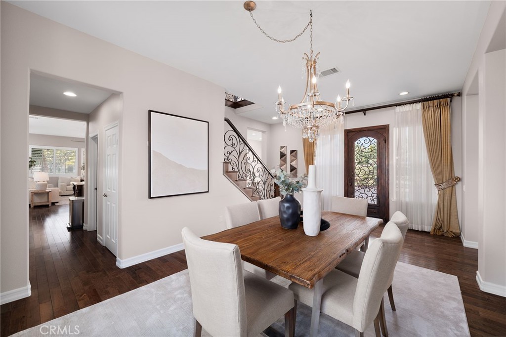 6364 Hidden Brook Place Rancho Cucamonga, CA 91739 - Photo 35 of 61 a dining room with wooden floor a chandelier a wooden table and chairs