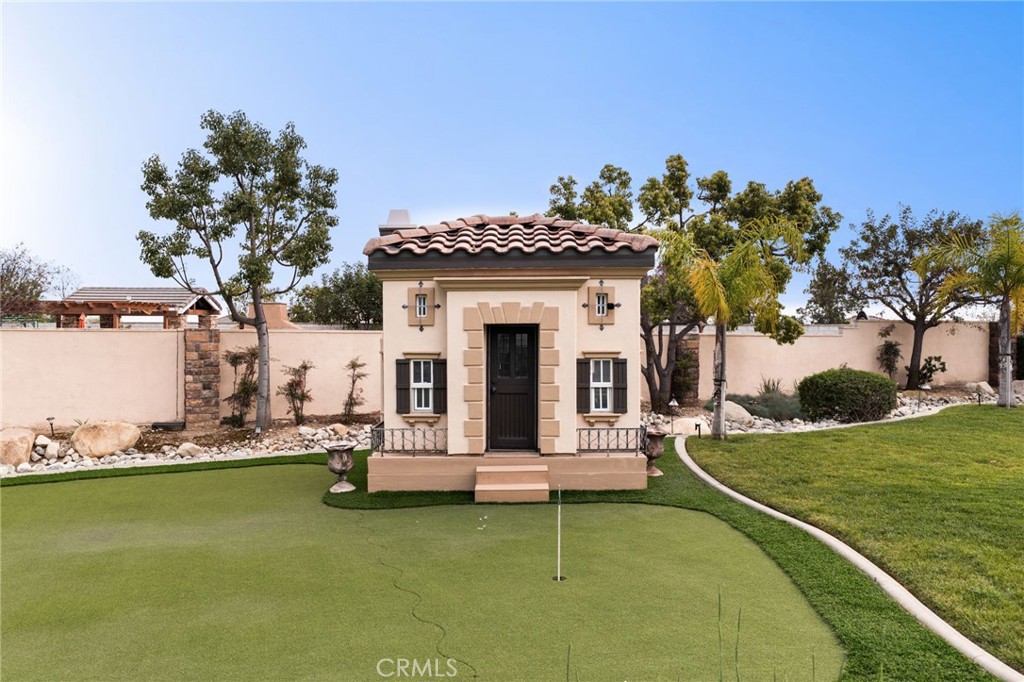 6364 Hidden Brook Place Rancho Cucamonga, CA 91739 - Photo 51 of 61 a view of a house with pool lawn chairs and a yard with wooden fence