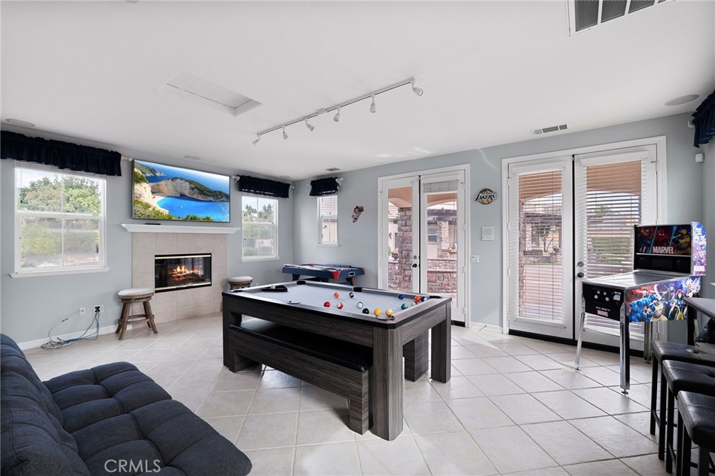 6364 Hidden Brook Place Rancho Cucamonga, CA 91739 - Photo 58 of 61 a living room with furniture a flat screen tv and a fireplace