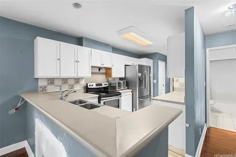 a kitchen that has a lot of cabinets a sink and a stove in it