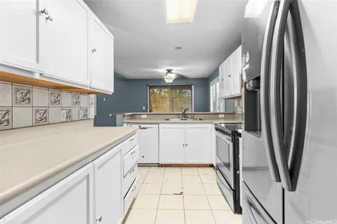 a kitchen with white cabinets and sink