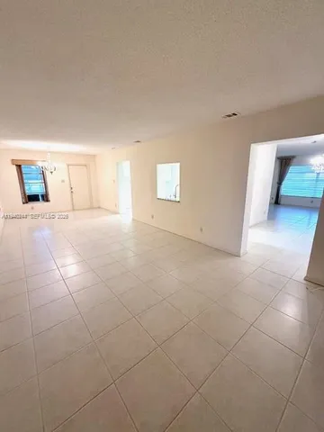 a view of a living room with kitchen and chandelier