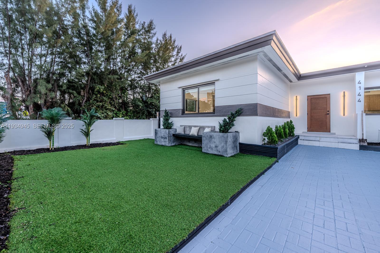4144 Alton Road Miami Beach, FL 33140 - Photo 2 of 17 a front view of house with yard and outdoor seating