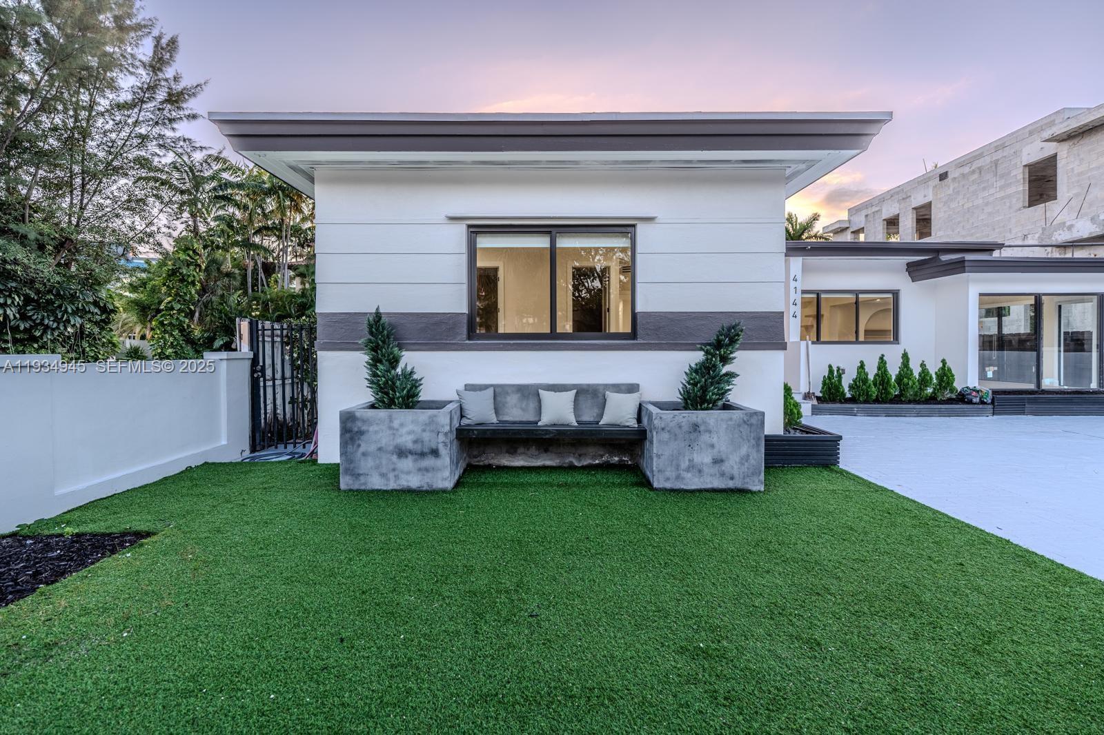 4144 Alton Road Miami Beach, FL 33140 - Photo 3 of 17 a view of a house with backyard sitting area and garden