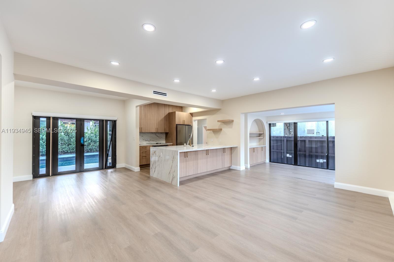 4144 Alton Road Miami Beach, FL 33140 - Photo 7 of 17 a view of an empty room with wooden floor and a window