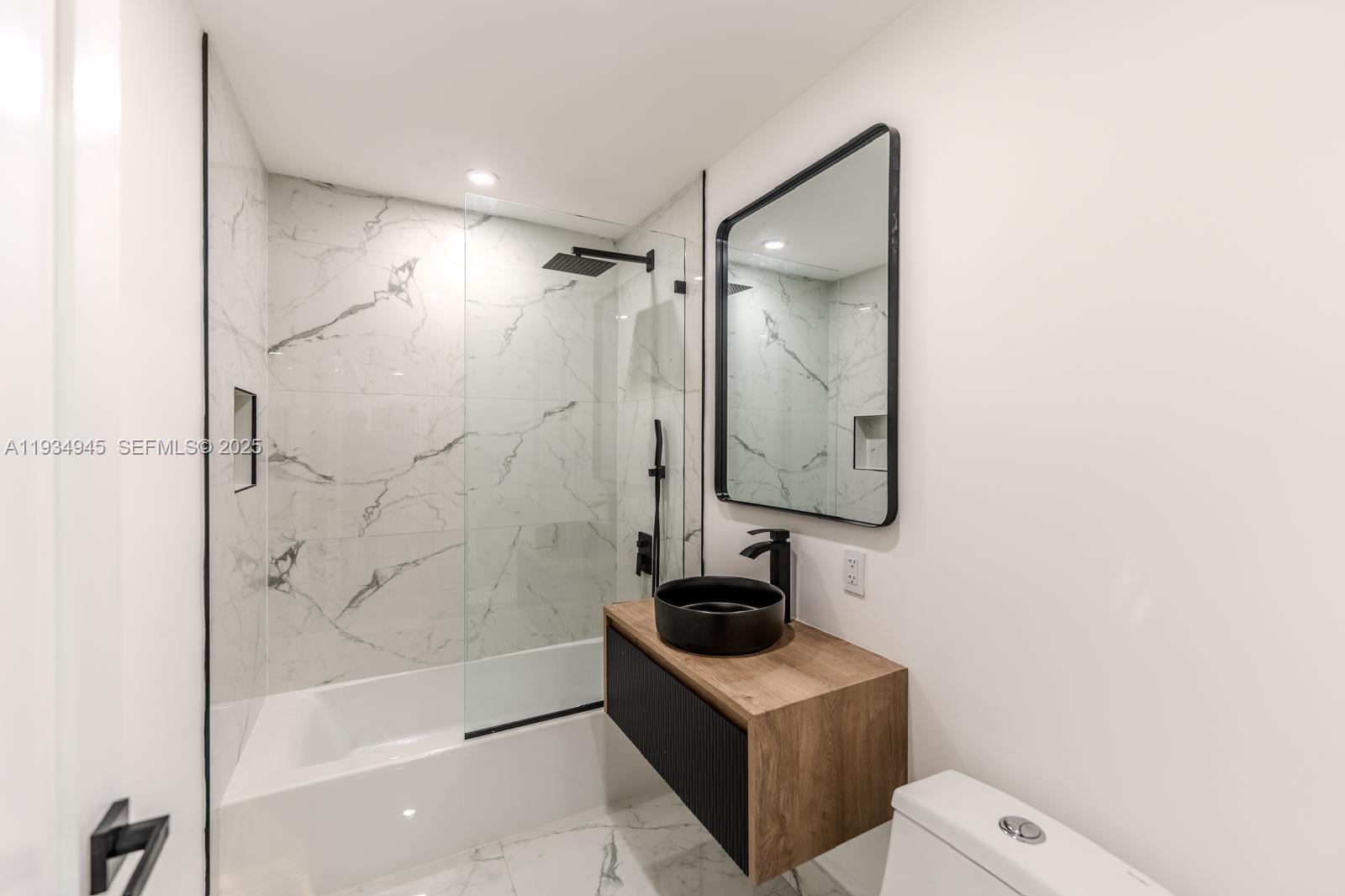 4144 Alton Road Miami Beach, FL 33140 - Photo 9 of 17 a bathroom with a shower a sink and mirror