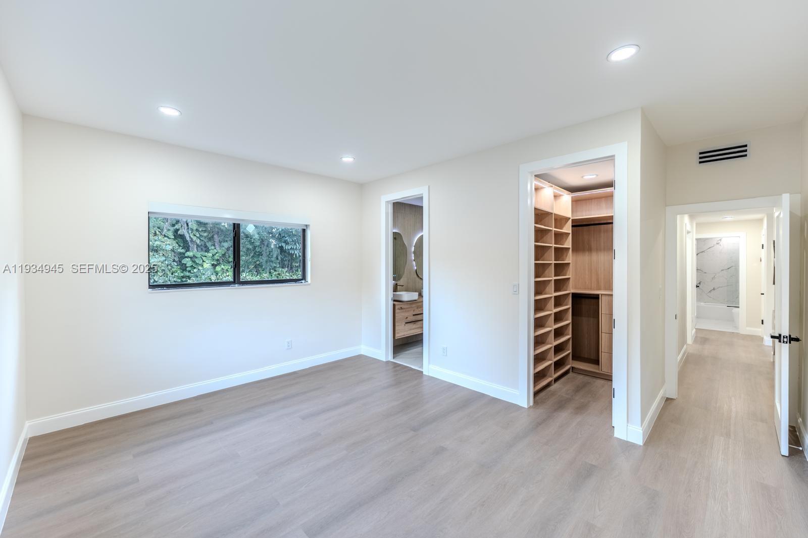 4144 Alton Road Miami Beach, FL 33140 - Photo 10 of 17 an empty room with wooden floor closet and windows