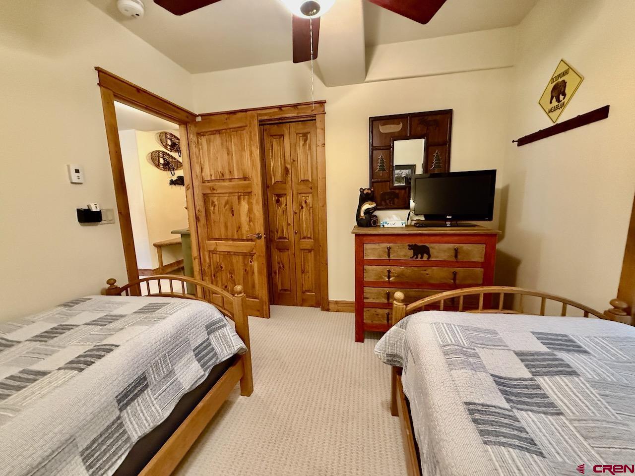9 Hunter Hill Road, Unit 205 Crested Butte, CO 81225 - Photo 20 of 28 a bedroom with a bed and a flat tv screen on dresser
