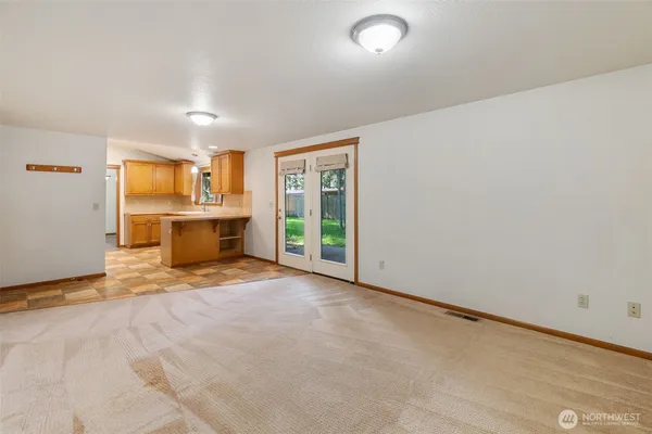 a view of an empty room with window and wooden floor