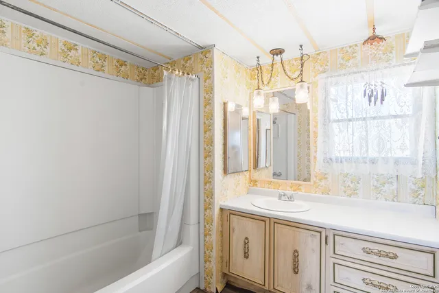 a bathroom with a granite countertop sink and a bathtub