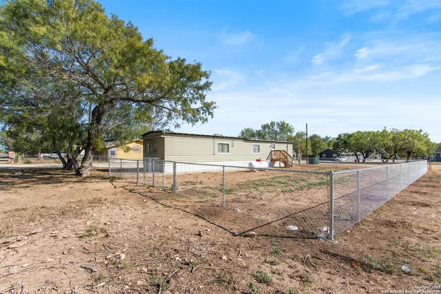 a view of a yard with wooden fence