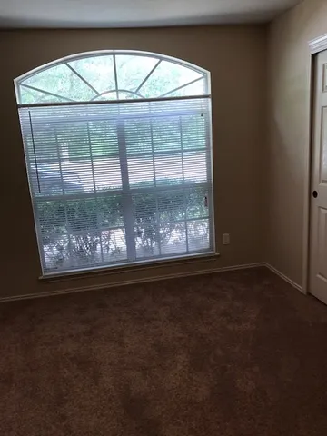 a view of a room with an empty floor and a window