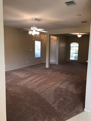 en empty room with windows and chandelier