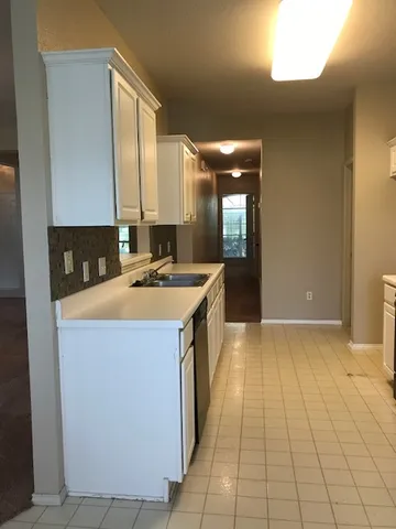 a kitchen with a sink a counter top space and cabinets