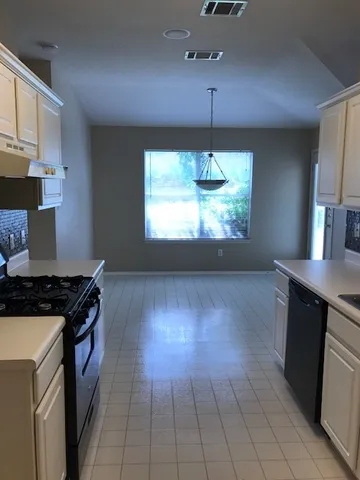 a kitchen with a stove and a wooden cabinets
