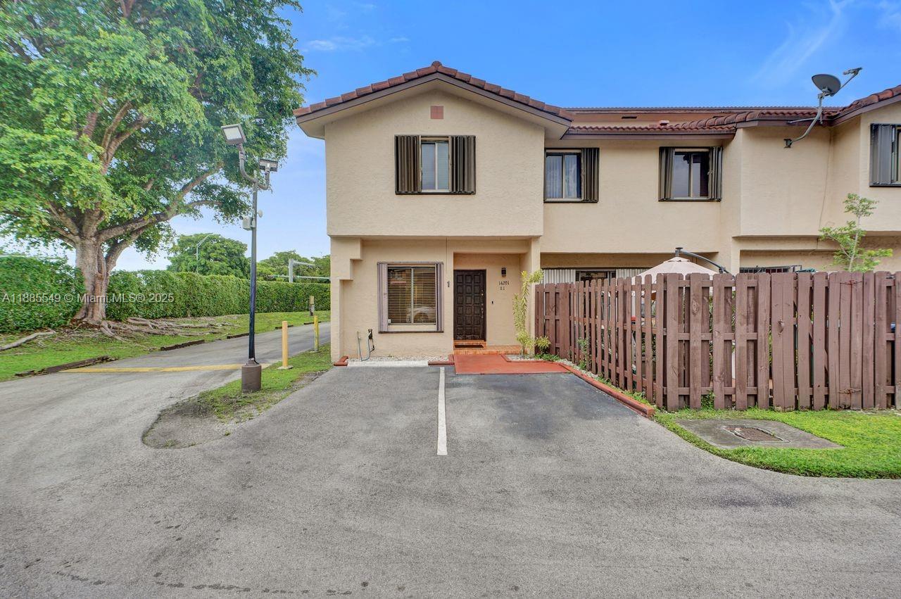 a view of a house with a small yard and wooden fence