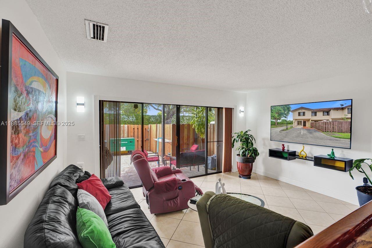 14201 Southwest 57th Lane, Unit 1A7 Miami, FL 33183 - Photo 13 of 48 a bedroom with furniture and a large window