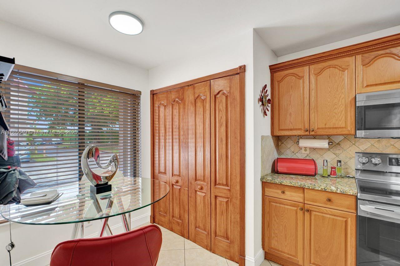 14201 Southwest 57th Lane, Unit 1A7 Miami, FL 33183 - Photo 19 of 48 a kitchen with stainless steel appliances granite countertop a stove a sink and a microwave