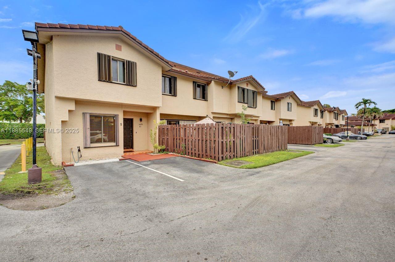 14201 Southwest 57th Lane, Unit 1A7 Miami, FL 33183 - Photo 2 of 48 a view of a house with a yard and large tree