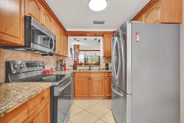 a kitchen with stainless steel appliances granite countertop a refrigerator and a sink
