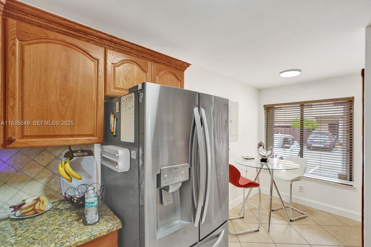 14201 Southwest 57th Lane, Unit 1A7 Miami, FL 33183 - Photo 23 of 48 a kitchen with a refrigerator and table chair