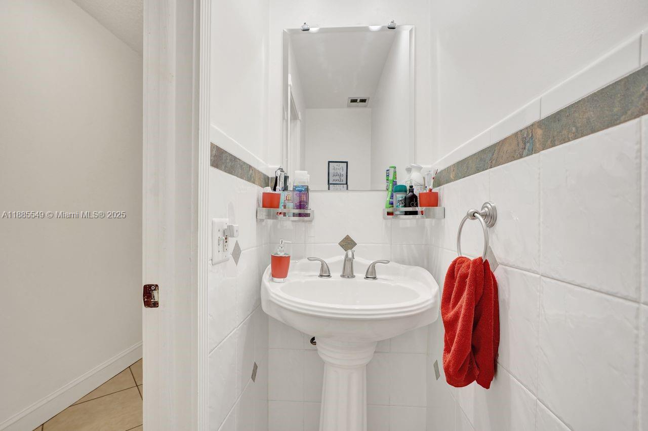 14201 Southwest 57th Lane, Unit 1A7 Miami, FL 33183 - Photo 24 of 48 a bathroom with a sink and a mirror