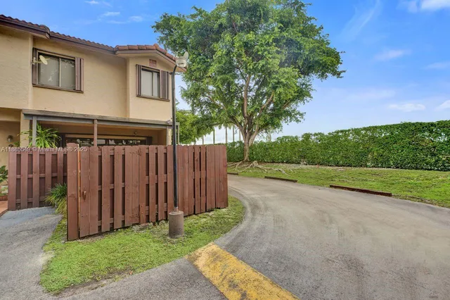 a view of a house with backyard and trees