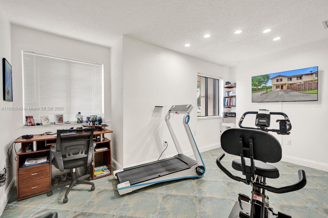 14201 Southwest 57th Lane, Unit 1A7 Miami, FL 33183 - Photo 32 of 48 a view of a workspace with gym equipment
