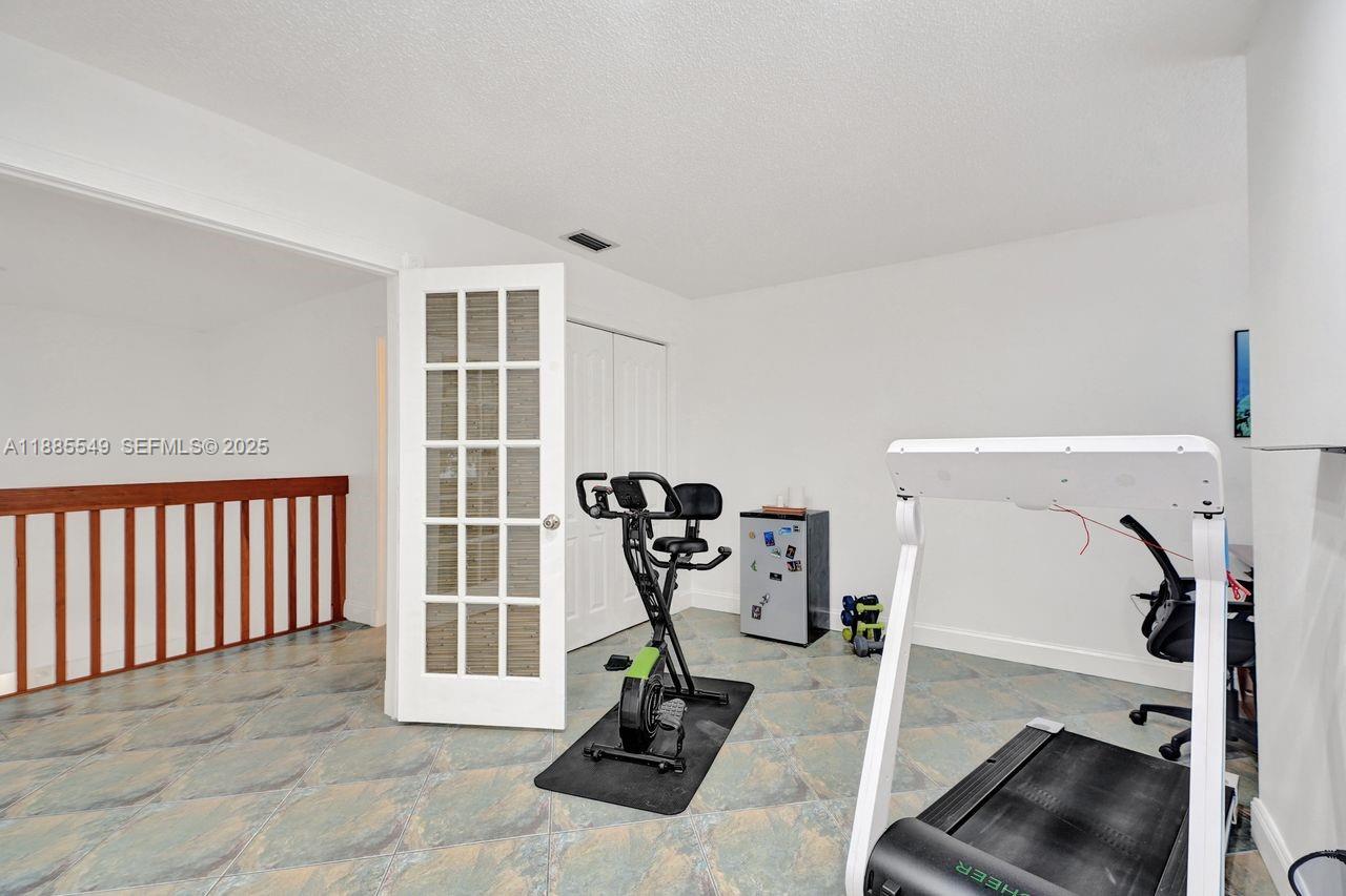 14201 Southwest 57th Lane, Unit 1A7 Miami, FL 33183 - Photo 33 of 48 a view of a room with gym equipment
