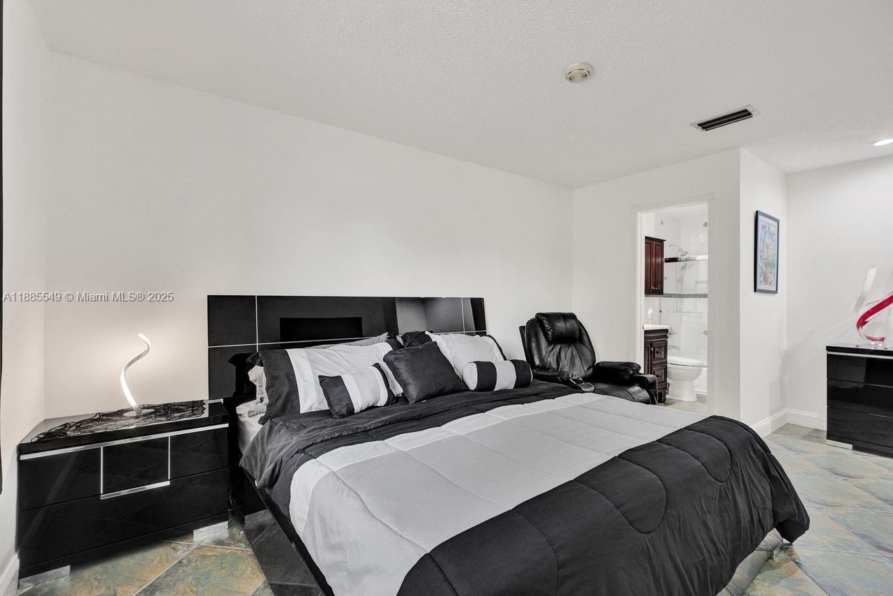 14201 Southwest 57th Lane, Unit 1A7 Miami, FL 33183 - Photo 35 of 48 a bedroom with a bed and lamp