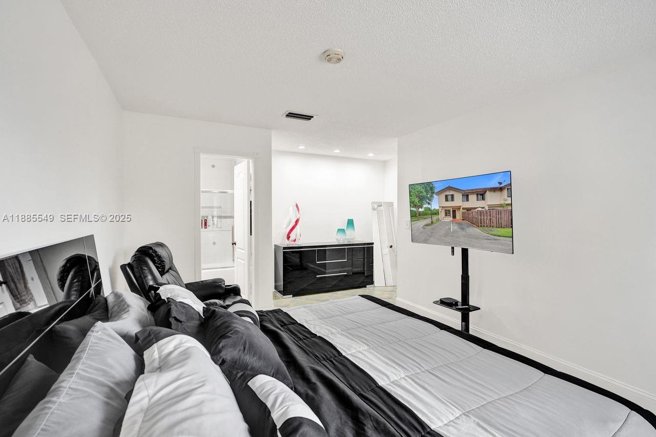 14201 Southwest 57th Lane, Unit 1A7 Miami, FL 33183 - Photo 36 of 48 a living room with furniture a flat screen tv and a wall painting