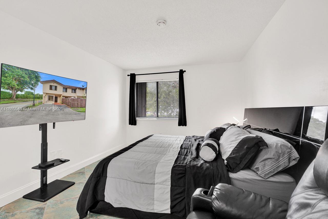 14201 Southwest 57th Lane, Unit 1A7 Miami, FL 33183 - Photo 37 of 48 a bedroom with a bed and window