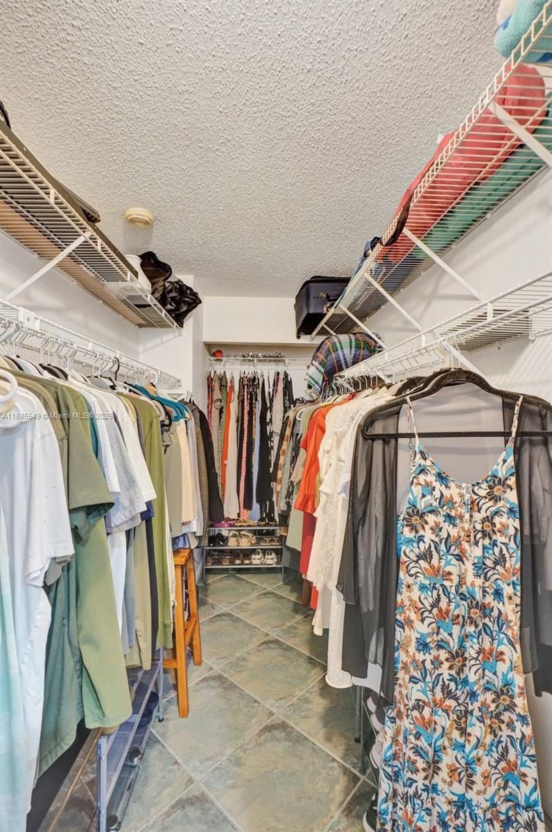 14201 Southwest 57th Lane, Unit 1A7 Miami, FL 33183 - Photo 39 of 48 a view of walk in closet with clothes and shoes