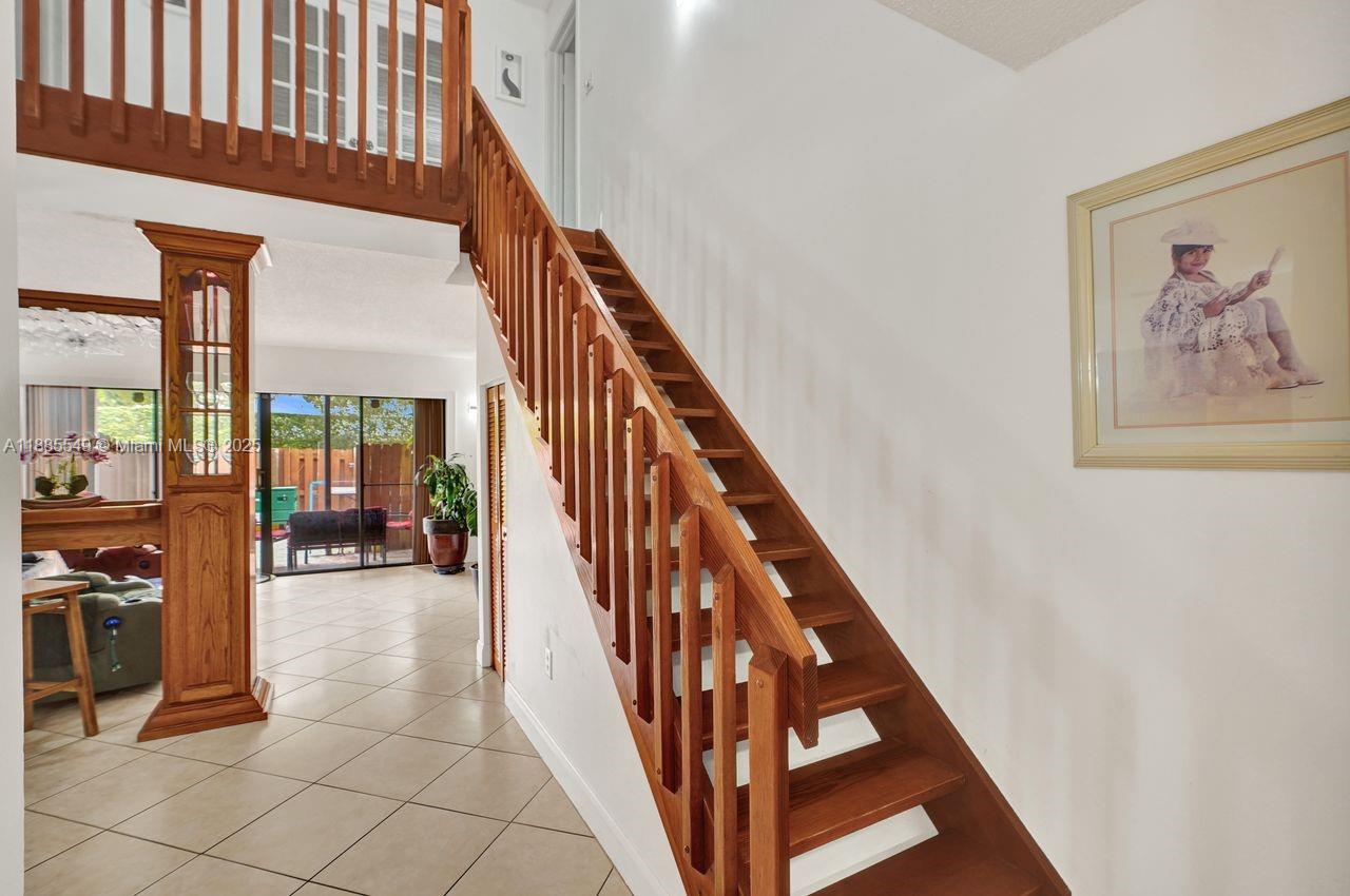 14201 Southwest 57th Lane, Unit 1A7 Miami, FL 33183 - Photo 10 of 48 a view of staircase with lots of frames on wall and a large window