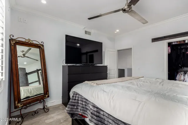 a bedroom with a large bed and a book shelf