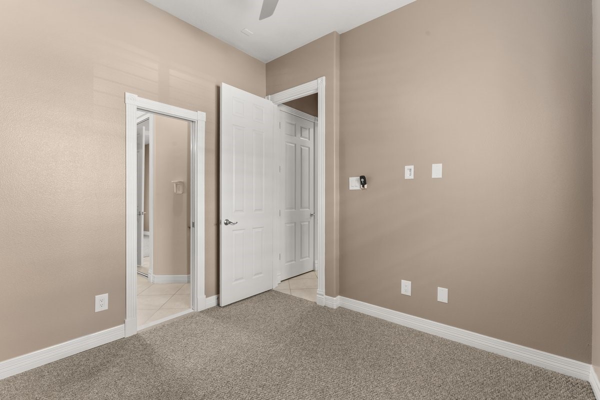 168 Lake Point Boulevard, Unit C102 Conroe, TX 77356 - Photo 18 of 35 This room features neutral-colored walls and carpet, with a white door leading to a tiled area. The space is simple and versatile, suitable for various uses.