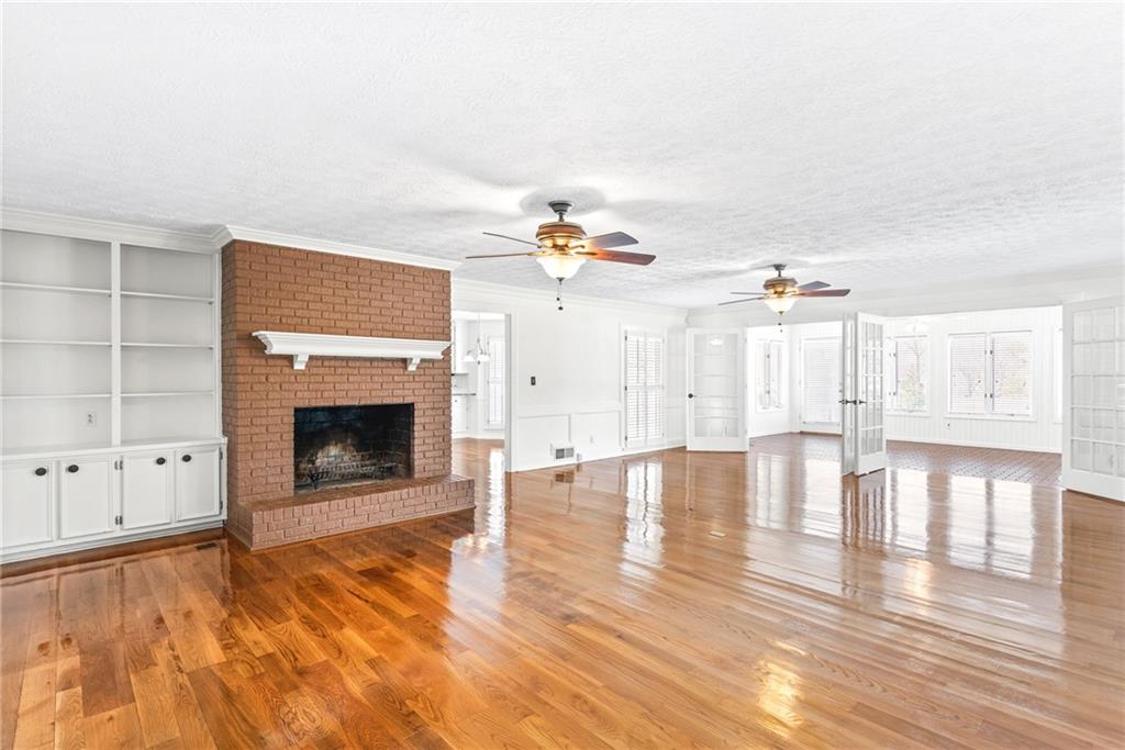 5184 West Price Road Suwanee, GA 30024 - Photo 12 of 25 a view of empty room with wooden floor and fireplace