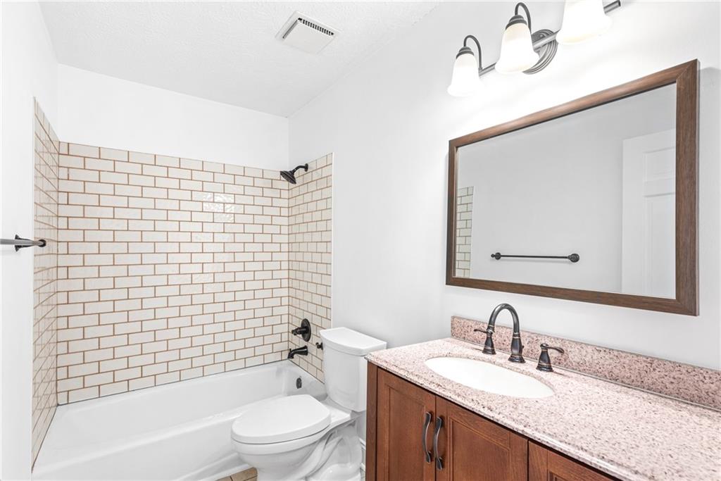 5184 West Price Road Suwanee, GA 30024 - Photo 9 of 25 a bathroom with a granite countertop bathtub sink vanity mirror and toilet